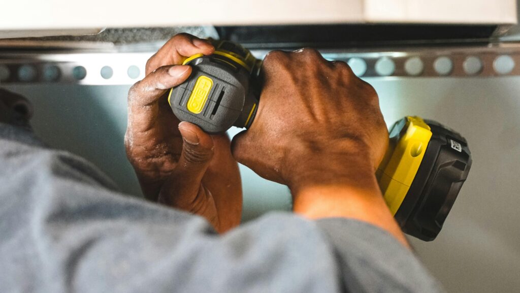 Close-up of worker's hands operating a power tool during a electrical task. Close-up of worker's hands operating a power tool during a electrical task.
